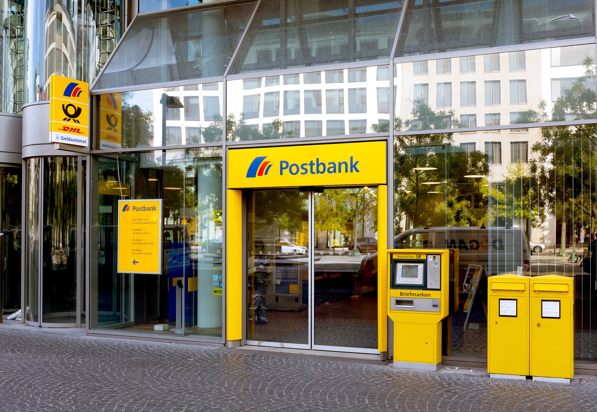 Eingang zum Postbankamt mit Geldautomat und Briefkasten