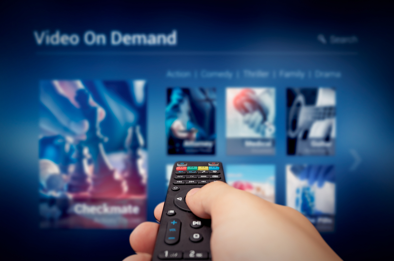 Video on Demand-Servicebildschirm mit Fernbedienung in der Hand