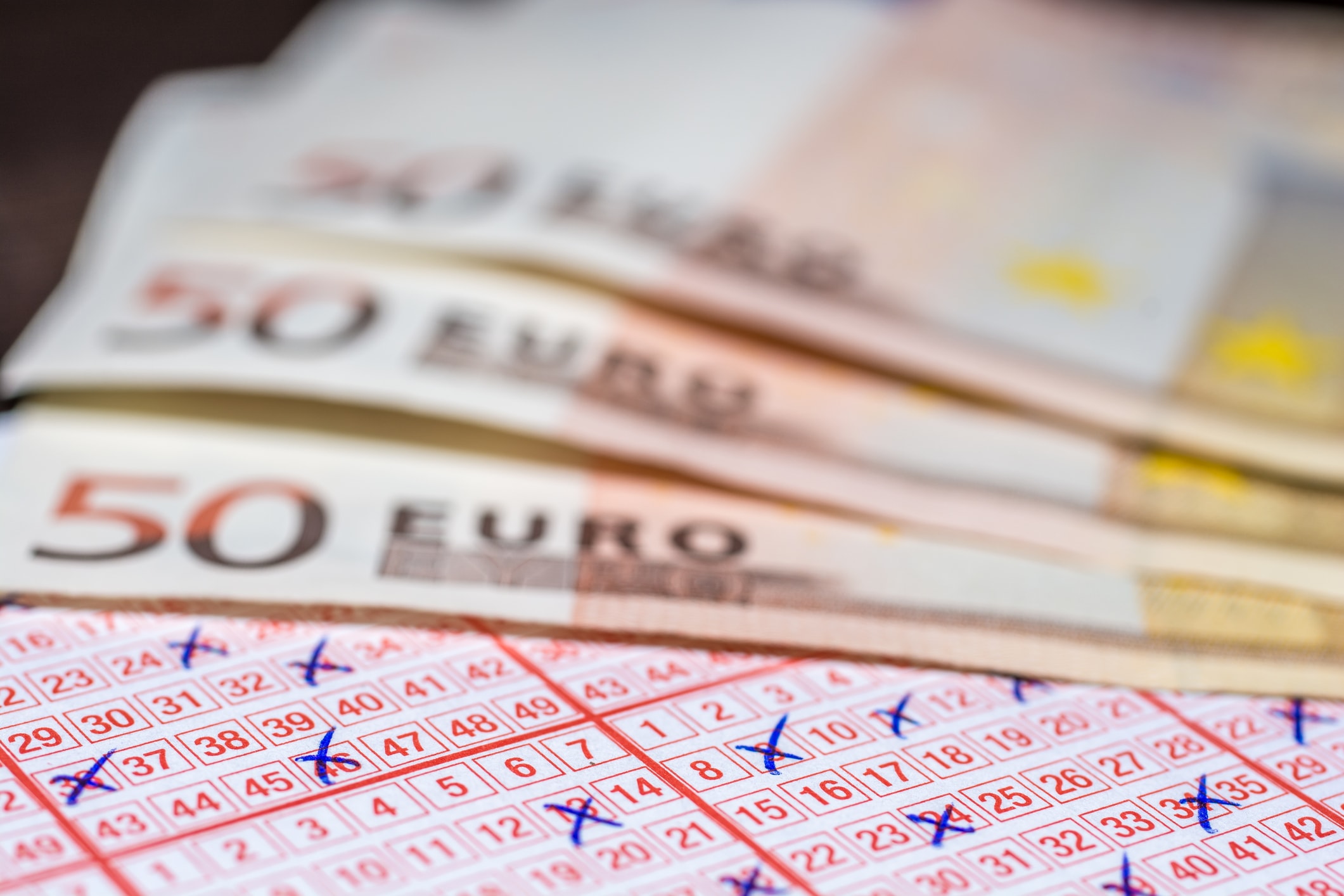Eurojackpot online spielen seriös: Banknoten und Lottoschein als Symbol für schnelles Geld